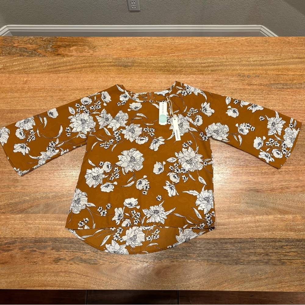 Brown, Cream and Black floral print blouse with a zipper in the back.